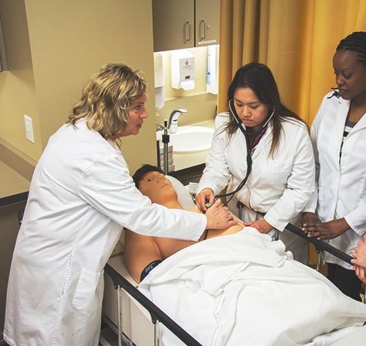 Nurses around mannequin