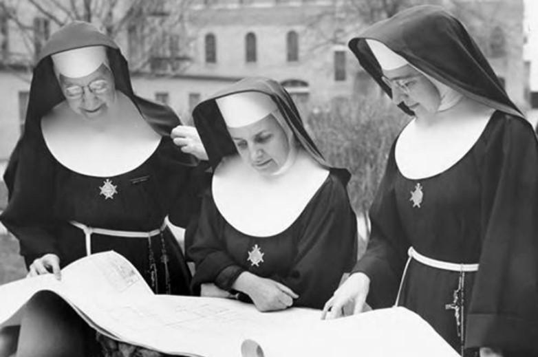 Three FSPA sisters viewing building blueprints.