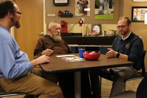 Gerard Glab, Father Conrad Targonski and Brandon Schoonover in Viterbo University's military student lounge