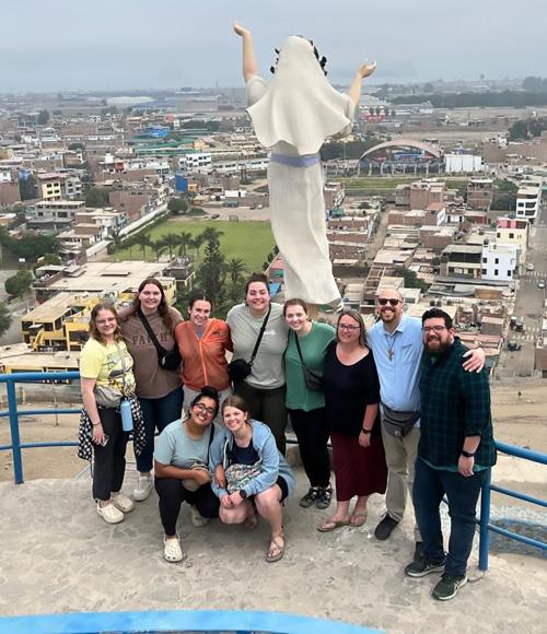 The Viterbo University group that visited Casa Hogar in Peru is pictured atop a hill behind the complex on which the Rev. Joseph Walijewski, founder of Casa Hogar, is buried. One task undertaken by the group during their visit was to fill vessels that serve to irrigate plants on the path to his gravesite.