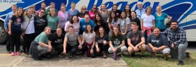 Group photo of 2020 spring break service group in front of bus. 