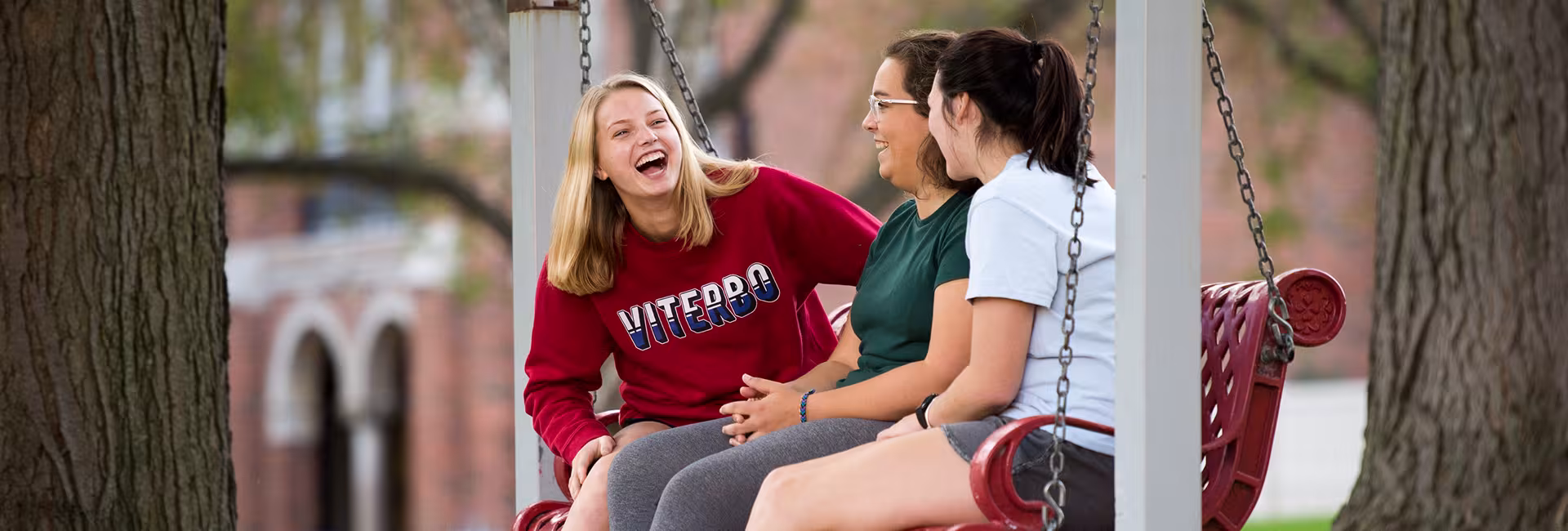 Students laughing on bench